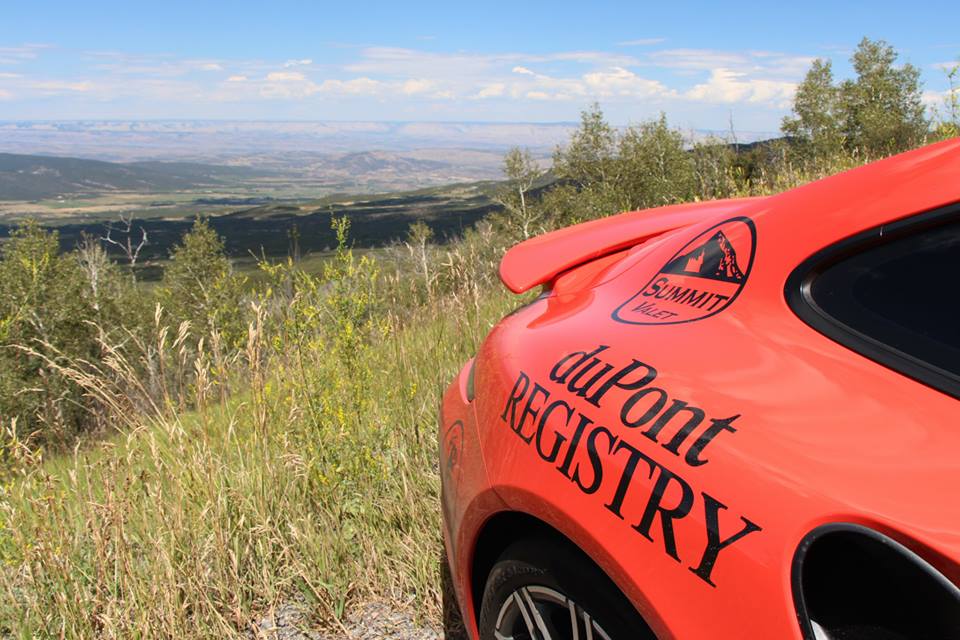 Summit Valet branded Porsche photographed on a Colorado mountain road